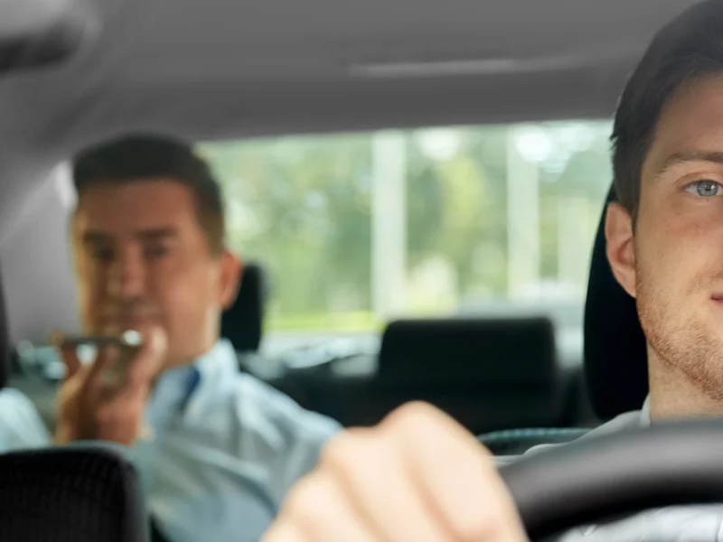Taxi Driver Driving Another Man in Taxi