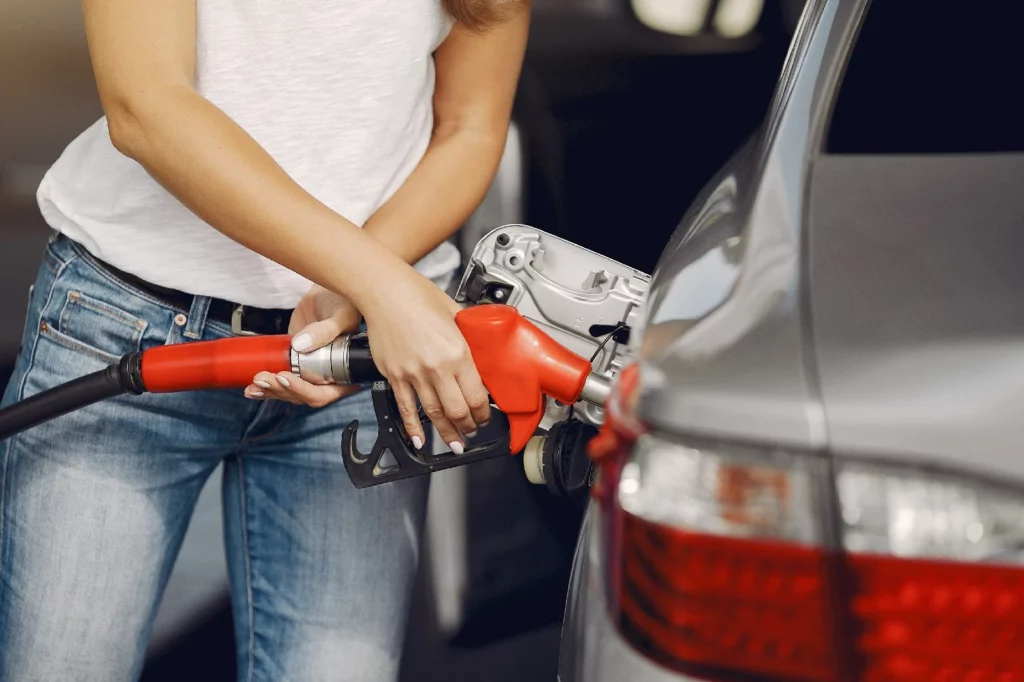 Woman pumping gas in car using Insurance for HyreCar Fleet Owners